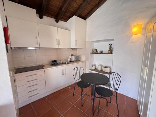 a small kitchen with a table and chairs in it at Casinha do Chafariz - Casas da Amieira in Amieira