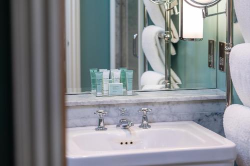 a bathroom with a white sink and a mirror at Roslin Beach Hotel in Southend-on-Sea