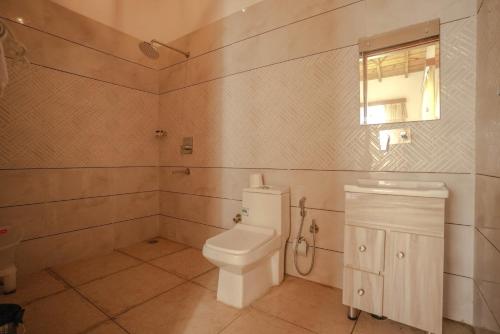 a bathroom with a white toilet and a window at KK Jungle View Resort in Kota Bāgh