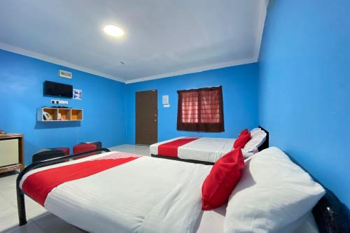 two beds in a room with blue walls at Capital O 90168 Serambi Pelangi Chalet in Changlun