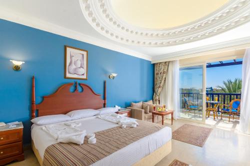 Un dormitorio con una cama grande con paredes azules. en Titanic Beach - Families and Couples only, en Hurghada