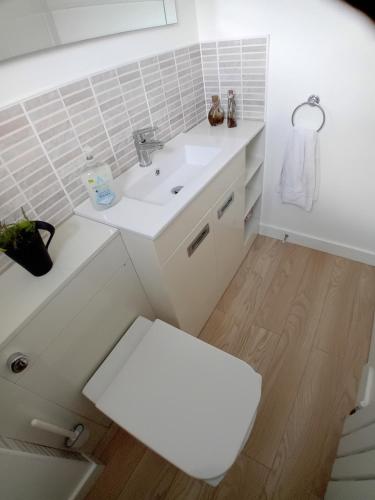 a bathroom with a white sink and a toilet at 'Ks' Yard in Great Dunmow