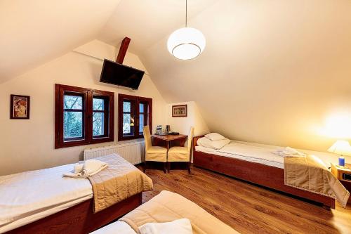 Pokój na poddaszu z 2 łóżkami i telewizorem w obiekcie REZYDENCJA MARIA Karpacz w mieście Karpacz