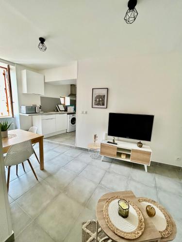un salon avec une télévision et une table dans l'établissement L'appart cosy Cruas ღ au pied du château, à Cruas