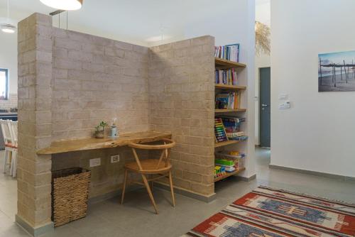 a brick wall in a room with a wooden desk at Nof Zuqim in Zuqim