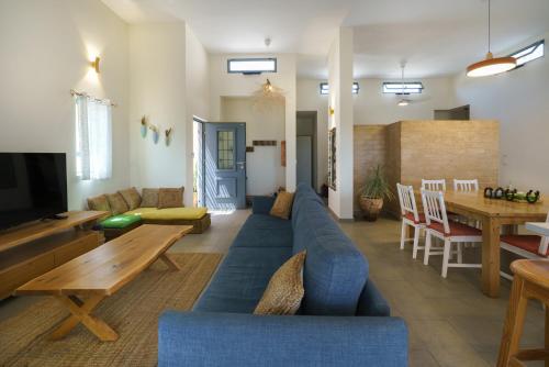 a living room with a blue couch and a table at Nof Zuqim in Zuqim