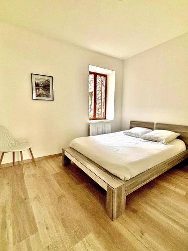 a bedroom with a bed and a chair and a window at L'appart cosy Cruas ღ au pied du château in Cruas