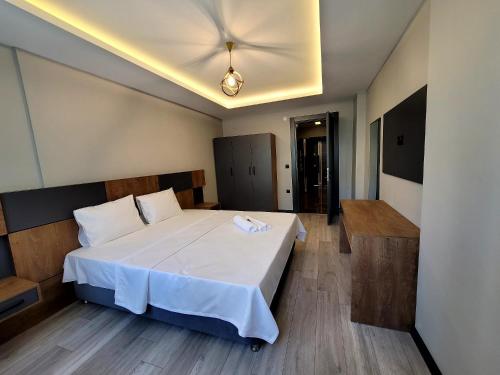 a bedroom with a large white bed with a ceiling at Levent Apart in Trabzon
