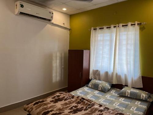 a small bedroom with a bed and a window at Disang Guest House in Guwahati