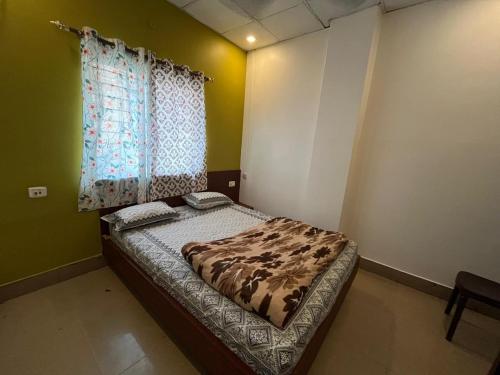 a bed in a room with a window at Disang Guest House in Guwahati