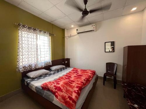 a bedroom with a bed and a ceiling fan at Disang Guest House in Guwahati