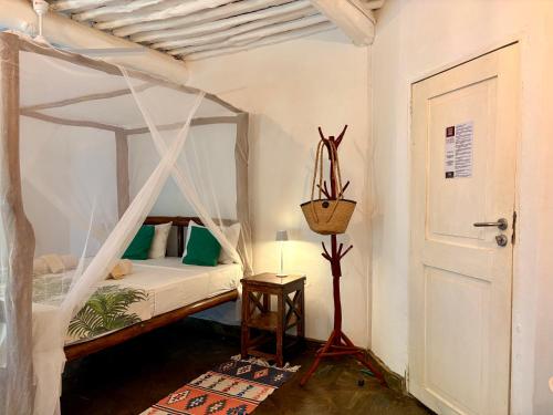 a bedroom with a canopy bed in a room at Casa Hera Diani in Diani Beach