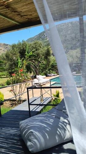 a mattress on a porch with a view of a pool at Polyxeni Apartments & Rooms in Qeparo