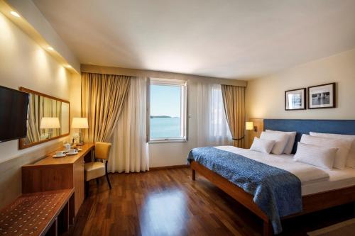 a hotel room with a bed and a window at Valamar Riviera Hotel & Residence in Poreč