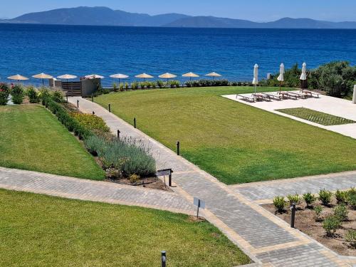 a view of a lawn with umbrellas and the ocean at SeaSide Village in Politiká