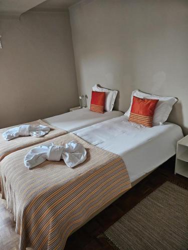 two beds sitting next to each other in a room at Casas Sebastião - Tourist House in Caminha