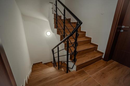 a staircase with a black metal rail and wooden floors at Villa Petra in Ohrid