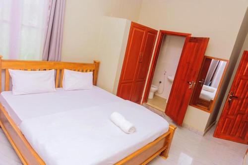 a bedroom with a white bed with a mirror at 4Luxury Hotel in Moshi