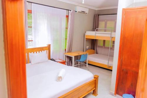 a bedroom with a bed and a bunk bed and a desk at 4Luxury Hotel in Moshi
