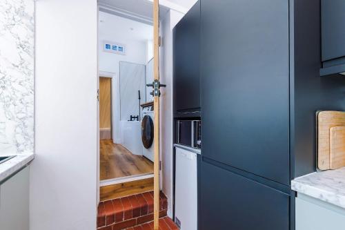a kitchen with blue cabinets and a washer and dryer at Cozy 3-Bed Home by 53 Degrees Property, Perfect for Business & Groups! in Leek