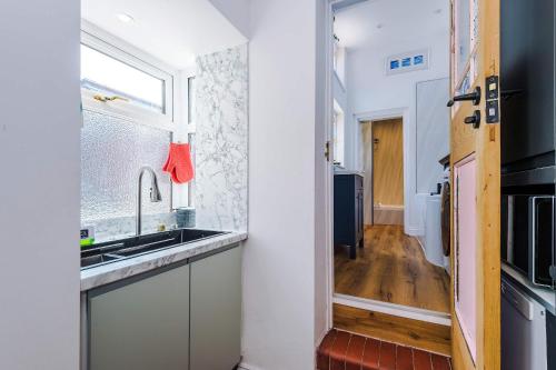 a kitchen with a sink and a window at Cozy 3-Bed Home by 53 Degrees Property, Perfect for Business & Groups! in Leek