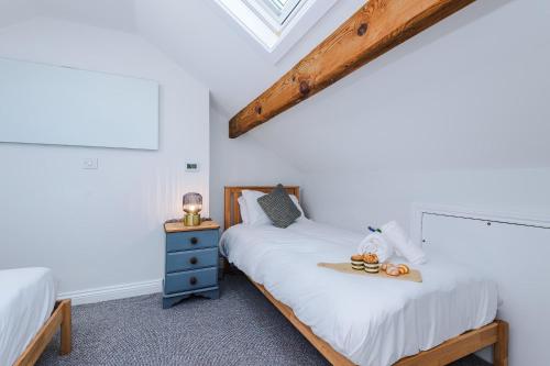 a bedroom with two twin beds and a window at Cozy 3-Bed Home by 53 Degrees Property, Perfect for Business & Groups! in Leek