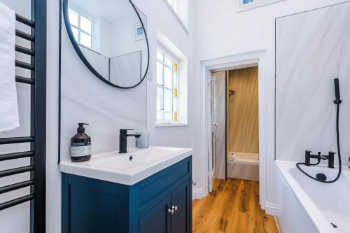 a bathroom with a sink and a mirror on the wall at Cozy 3-Bed Home by 53 Degrees Property, Perfect for Business & Groups! in Leek