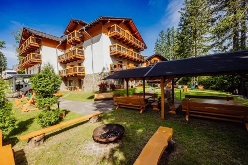a large building with benches in front of it at Hotel Na Skarpie in Szklarska Poręba