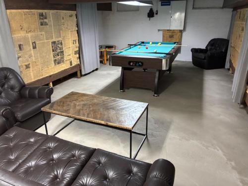 a living room with a pool table and leather couches at m i g l i o r e in Pargas