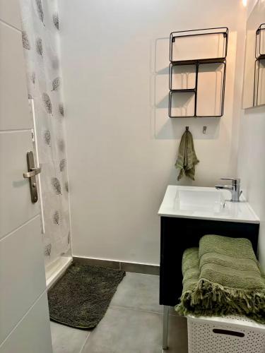 a white bathroom with a sink and a mirror at L'appart cosy Cruas ღ au pied du château in Cruas