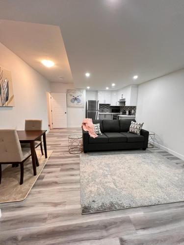 a living room with a black couch and a table at Cozy Corner - 1 bedroom suite - 15 mins from airport in Calgary