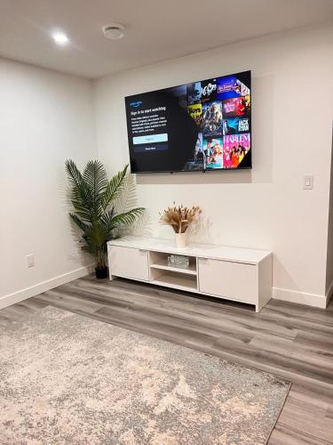 a living room with a tv on the wall at Cozy Corner - 1 bedroom suite - 15 mins from airport in Calgary