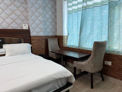 a bedroom with a bed and a desk and a table at Hotel HD Residency A Unit By Hotel Harbans in Patiāla