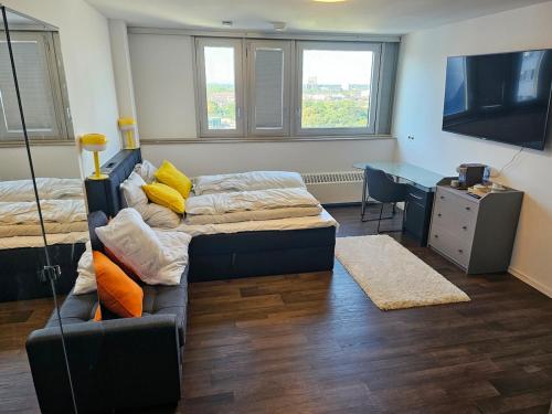 a room with two beds and a desk and a couch at Ehrenfeld - Bright 32m2 Flat in Cologne