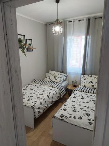 a bedroom with two beds and a chandelier at W sosnowym lesie in Lubniewice