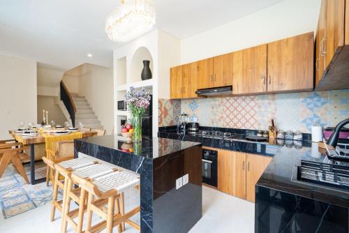 a kitchen with wooden cabinets and a dining room at Villa Amaia Canggu in Kerobokan