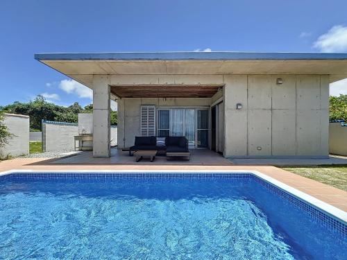 a swimming pool in front of a house at ulu Okinawa Resort in Motobu