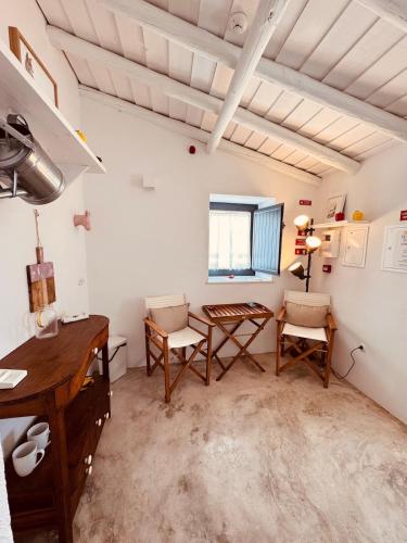 a room with a table and chairs and a desk at Casinha do Largo - Casas da Amieira in Amieira