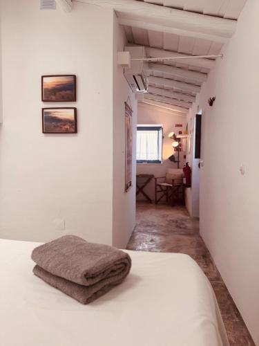 a bedroom with white walls and a bed with a blanket at Casinha do Largo - Casas da Amieira in Amieira