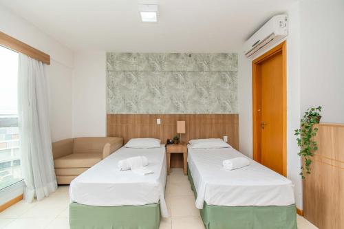 a hotel room with two beds and a couch at BSB STAY Premium Flats Particulares - Saint Moritz in Brasilia