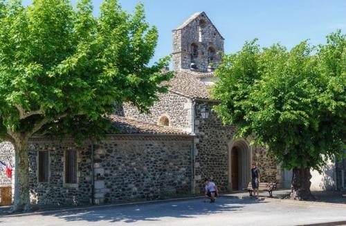 ein Steingebäude mit einem Turm darauf in der Unterkunft Appartement en cœur de village au pied du château avec 2 balcons in Alba-la-Romaine