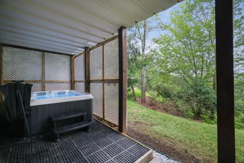 a screened in porch with a hot tub on a patio at Mountainview Vista 1 Mile To Water Park & Ski in Tannersville