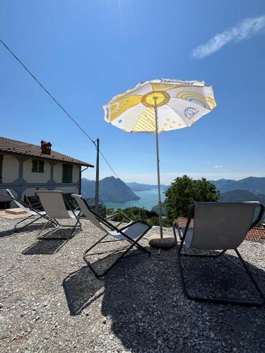 two chairs and an umbrella on a roof at Panorama Verde Lago - Mountain Lake Iseo Hospitality in Bossico