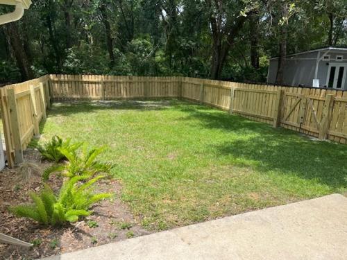 un patio trasero con una valla de madera y un patio en BARNHILL B DUPLEX Duplex, en Jekyll Island