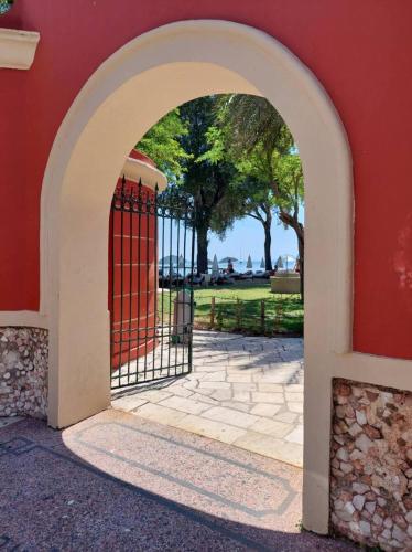 an entrance to a red building with a gate at Apartment Adriana Mon Repos in Anemómylos