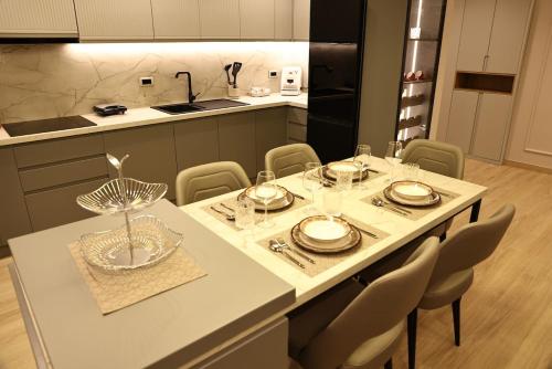 a kitchen with a table with plates and glasses on it at Nova Luxury Apartment in Durrës