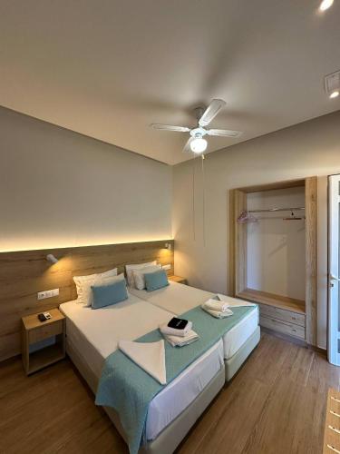 a bedroom with a large bed with a ceiling fan at EYTYXHS Studios in Palaiochora