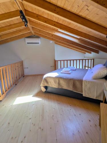 a bedroom with a bed and a wooden floor at Mirabilis Suites in Vasiliki
