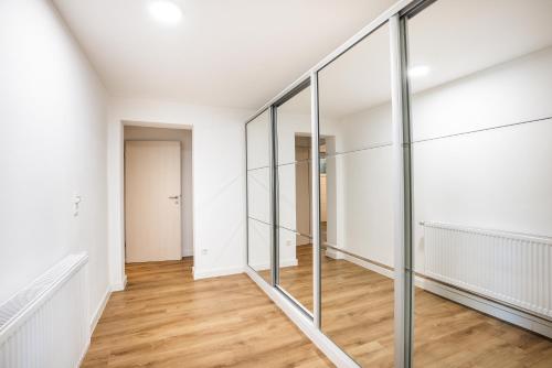 a hallway with glass walls and wood floors at Modernes Apartment in Mistelgau in Mistelgau