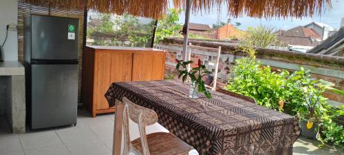 a table and a refrigerator on a balcony at Rumah Sedana Ubud Centre in Ubud